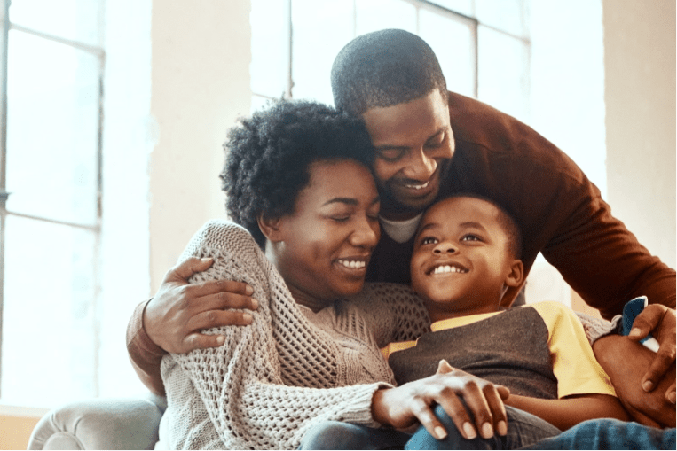 Joyful parents give an affectionate hug to their son.